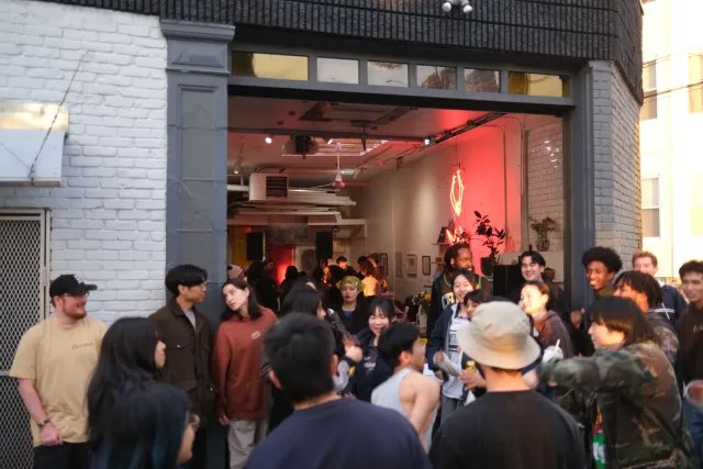 Option four: a gallery with a roll-up door open to a sidewalk crowd